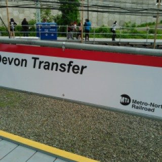 This sign marks the Devon Transfer, a temporary station built along Metro-North's New Haven Line to allow customers to transfer to the Waterbury Branch while repair work takes place on the Devon Bridge. This station is located in the Devon section of Milford, Connecticut, between the Stratford and Milford stations on the New Haven Line. The temporary station opened 4 May 2015; the repair work is expected to take six months.