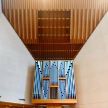 The organ case below the sloped acoustical ceiling in the northwest corner of the sanctuary. Behind the organ case is the corner of Lexington Avenue and East 54th Street.